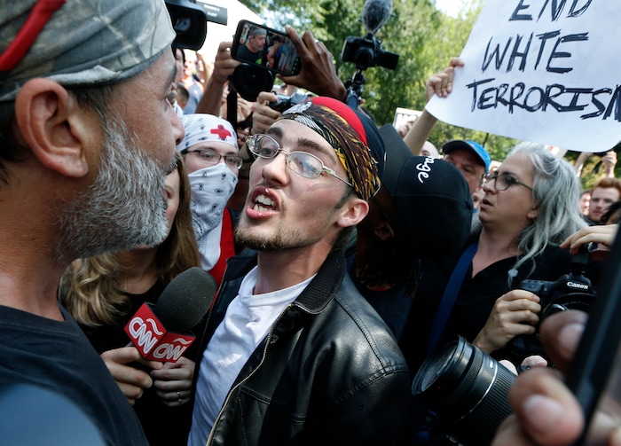 A supporter of President Donald Trump, center, argues with a counterprotester, left, at a "Free Speech" rally by conservative activists on Boston Common, Saturday, Aug. 19, 2017, in Boston.  Thousands of counterprotesters marched through downtown Boston on Saturday, chanting anti-Nazi slogans and waving signs condemning white nationalism ahead of a rally being staged by conservative activists a week after a Virginia demonstration turned deadly.  (AP Photo/Michael Dwyer)
