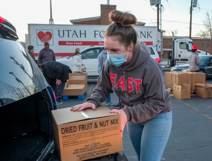 (Leah Hogsten | The Salt Lake Tribune) Volunteer Erin Johnson, 14, helps hand out food from the Utah Food Bank to needy families, Dec. 23, 2020.