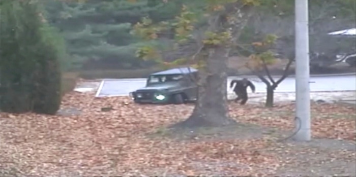 This image made from Nov. 13, 2017, surveillance video released by the United Nations command shows a North Korean soldier running from a jeep and later shot by North Korean soldiers. A North Korean soldier made a desperate dash to freedom in a jeep and then on foot, being shot at least five times as he limped across the border and was rescued by South Korean soldiers, according to dramatic video released by the U.S.-led U.N. command Wednesday. (United Nations Command via AP)