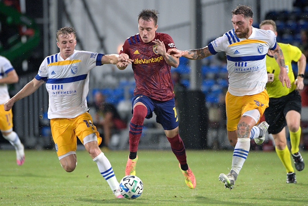 (AP Photo/Phelan M. Ebenhack) San Jose Earthquakes midfielder Jackson Yueill, left, and defender Guram Kashia, right, combine to take the ball from Real Salt Lake forward Corey Baird during the first half of an MLS soccer match Monday, July 27, 2020, in Kissimmee, Fla.