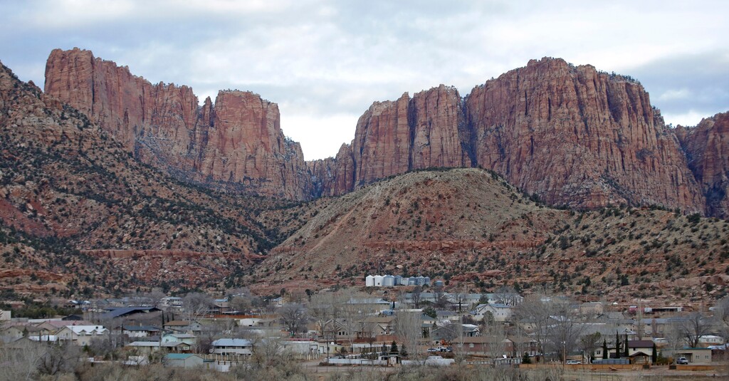 (Rick Bowmer | AP) This Dec. 16, 2014 photo shows Hildale, Utah, sitting at the base of Red Rock Cliff mountains, with its sister city, Colorado City, Ariz., in the foreground.