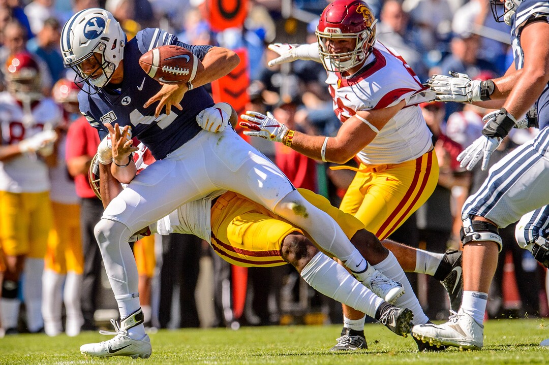 (Trent Nelson  |  The Salt Lake Tribune)  Brigham Young Cougars quarterback Zach Wilson (1) loses the ball as he's hit by USC Trojans defensive lineman Drake Jackson (99) as BYU hosts USC, NCAA football in Provo on Saturday Sept. 14, 2019.