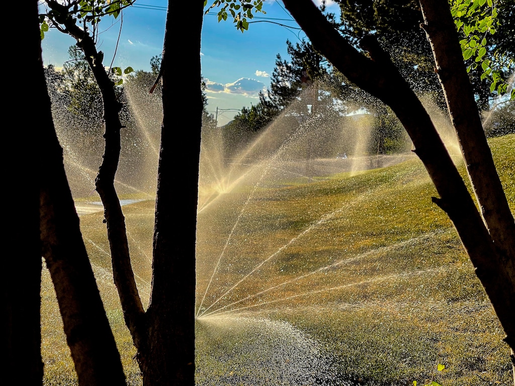 (Trent Nelson  |  The Salt Lake Tribune) Spinning sprinkler in Salt Lake City in June 2021. Salt Lake County is expected to approve water-saving measures that will convert sports fields to artificial turf and remove grass from parking strips on county-owned property.