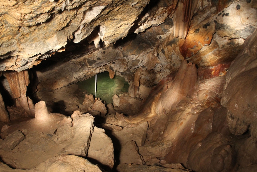 (Francisco Kjolseth  |  Tribune file photo)  A measuring stick far below keeps track of the depth of the Hansen Cave Lake that make up the far end of the introduction to caving tour at Mt. Timpanogos and where Martin Hansen conducted tours in the late 1800s. The side tour gives those 14 and older a chance to experience caving away from the developed trail and cave lights. With a helmet lamp and a ranger to guide you visitors experience tight spots that force you to crawl and scramble.