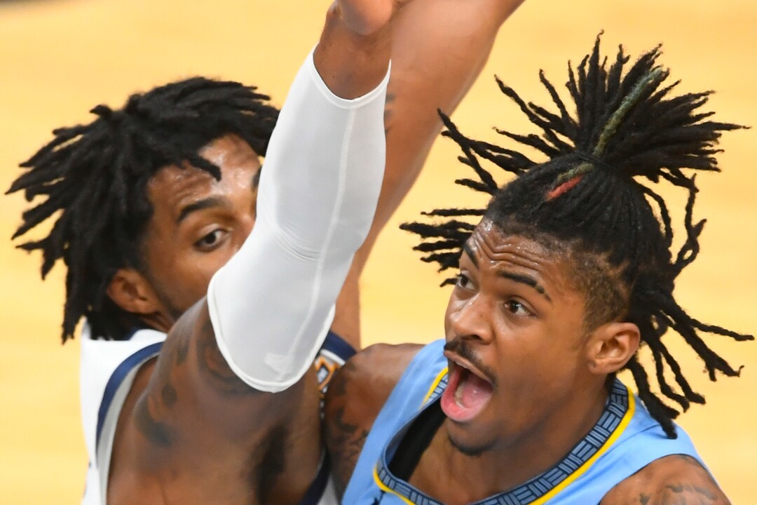 Memphis Grizzlies guard Ja Morant (12) goes to the basket as Utah Jazz center Derrick Favors defends during the first half of Game 3 of an NBA basketball first-round playoff series Saturday, May 29, 2021, in Memphis, Tenn. (AP Photo/John Amis)