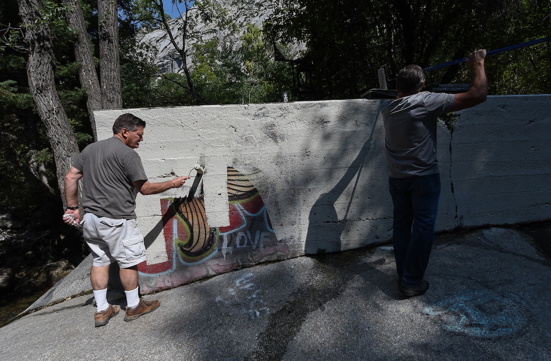 (Francisco Kjolseth  |  The Salt Lake Tribune)  Michael Nebeker, left, and Scott Whipperman cover up graffiti that has proliferated in lower Little Cottonwood Canyon, where vandals, often wielding cans of fluorescent-colored spray paint, have covered granite faces, trees and structures. The vandalism is particularly apparent along the Temple Quarry Trail and the creek at the Moon Rock swimming hole and former pavilion site. Volunteers using donated equipment and solvents spend thousands of hours removing the paint from the rocks only to see graffiti return to the same faces or on rock nearby.