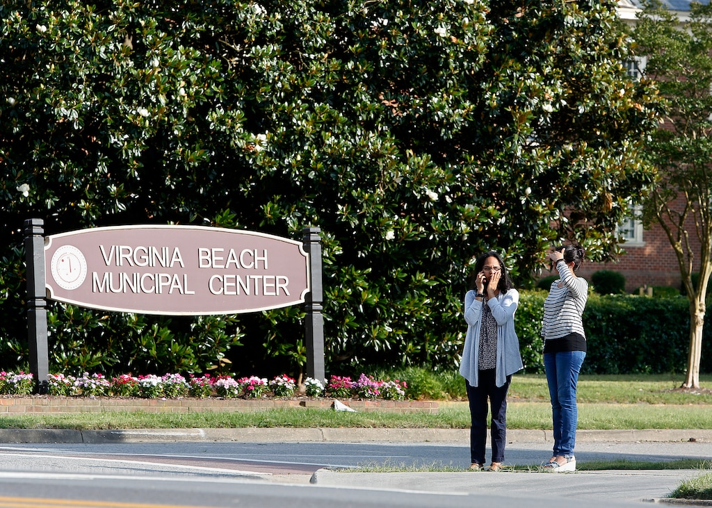 (Kaitlin McKeown/The Virginian-Pilot via AP) Women wait by an entrance to the Virginia Beach Municipal Center on Princess Anne Road following a shooting in the public works building Friday, May 31, 2019 in Virginia Beach, Va. A longtime city employee opened fire at a municipal building in Virginia Beach on Friday, killing 11 people before police shot and killed him, authorities said. Six other people were wounded in the shooting, including a police officer whose bulletproof vest saved his life, said Virginia Beach Police Chief James Cervera.