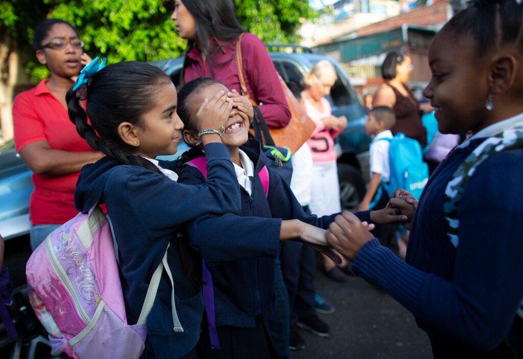 In this October 2, 2019 photo, girls play as they wait to enter on their first day of school, in Caracas, Venezuela. (AP Photo/Ariana Cubillos)