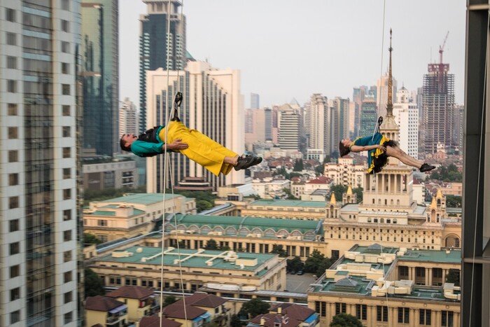 (Photo courtesy of James Adamson) Oakland, Calif.-based “vertical dance” company BANDALOOP performs in Shanghai, China. BANDALOOP will be appearing at the Utah Arts Festival June 21-24, and will perform twice daily (5:30 and 7 p.m.) on the six-story library glass wall above the reflecting pool.