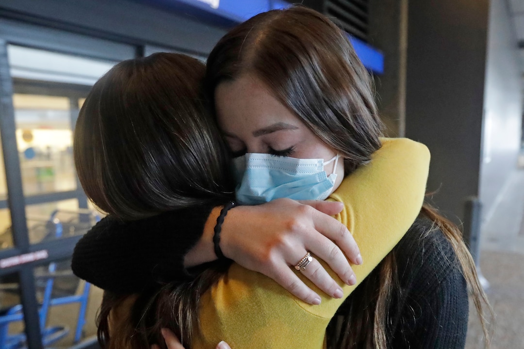 In this May 27, 2020, photo, Shaelee Palmer, 20, right, a missionary from The Church of Jesus Christ of Latter-day Saints, says goodbye to her mother Amber at Salt Lake City International Airport before leaving on her mission to North Carolina. After hastily bringing home 26,000 young men and women who were serving in foreign countries, the faith has begun sending many of them out again in their home countries with a new focus on online work that could stick even when the pandemic is over, church officials told The Associated Press. (AP Photo/Rick Bowmer)