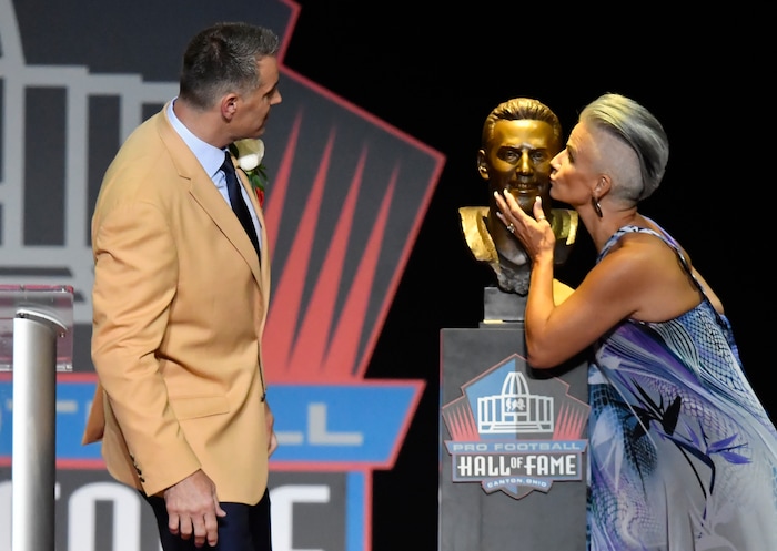 Former NFL quarter Kurt Warner, left, watches as his wife and presenter, Brenda Warner, kisses a bust of him before his speech during inductions at the Pro Football Hall of Fame on Saturday, Aug. 5, 2017, in Canton, Ohio. (AP Photo/David Richard)