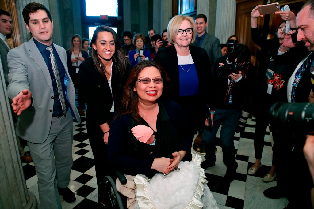 Sen. Tammy Duckworth, D-Ill., carries her baby Maile Pearl Bowlsbey as she heads to the Senate floor to vote, with Sen. Claire McCaskill, D-Mo., at right, on Capitol Hill, Thursday, April 19, 2018 in Washington. (AP Photo/Alex Brandon)