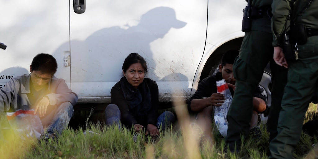FILE - In this Aug. 11, 2017, file photo, immigrants suspected of crossing into the United States illegally along the Rio Grande near Granjeno, Texas, are held by U.S. Customs and Border Patrol agents. Border Patrol arrests fell sharply in June  2018, to the lowest level since February, according to a U.S. official, ending a streak of four straight monthly increases. (AP Photo/Eric Gay, File)