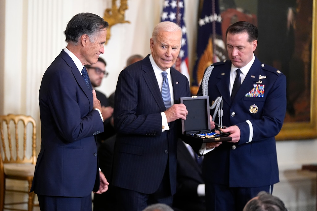 (Manuel Balce Ceneta | AP) President Joe Biden, center, posthumously presents the Presidential Medal of Freedom, the Nation's highest civilian honor, to former Sen. Mitt Romney, R-Utah, on behalf of his late father George Romney, in the East Room of the White House, Saturday, Jan. 4, 2025, in Washington.