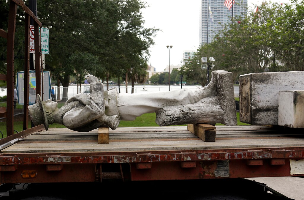 The top section of a Confederate statue called "Johnny Reb" is loaded on a truck before being removed from a downtown park Tuesday, June 20, 2017, in Orlando, Fla. The statue will be relocated to a Confederate section of a nearby cemetery. (AP Photo/John Raoux)