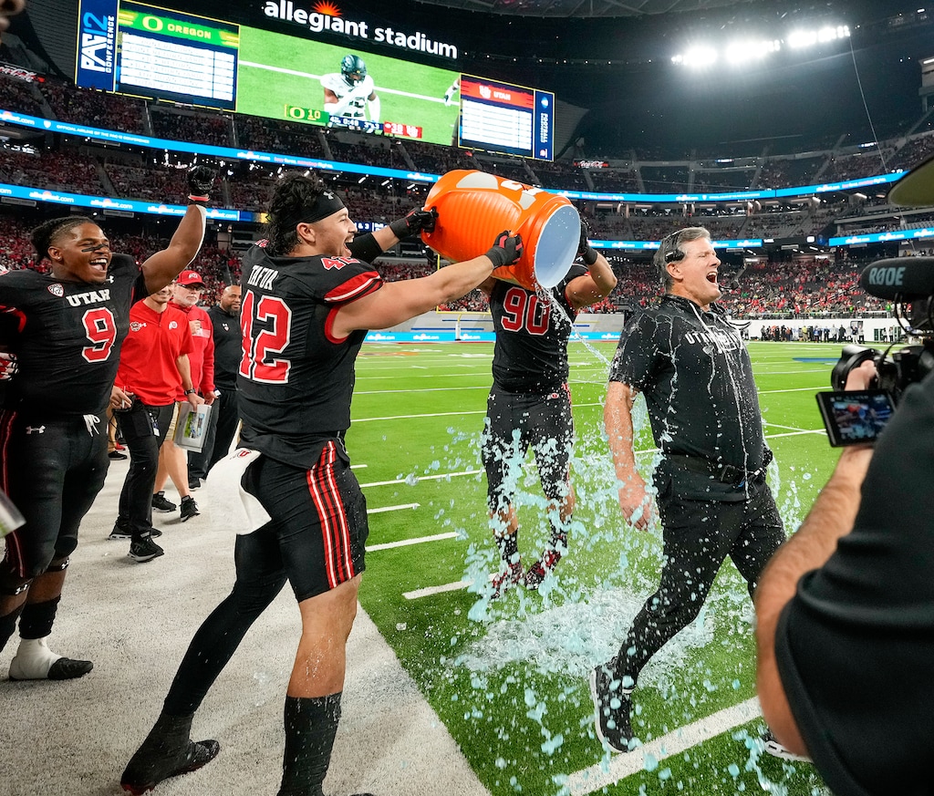 (Leah Hogsten | The Salt Lake Tribune) Utah Utes defensive tackle Devin Kaufusi (90) and Utah Utes defensive end Mika Tafua (42) drench Utah Utes head coach Kyle Whittingham. The Utes defeated the Oregon Ducks to win the 2021 Pac12 Football Championship title at Allegiant Stadium in Las Vegas, Dec 3, 2021.
