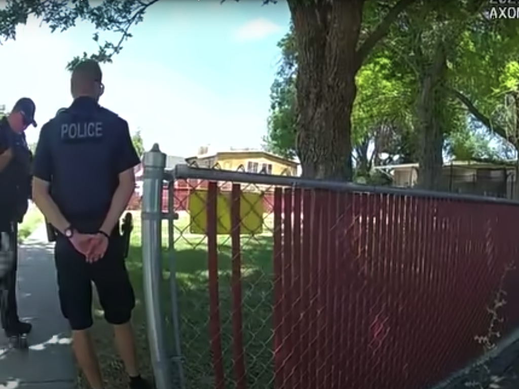 (Salt Lake City Police Department) Officers Benzon (right) and Abel Bromley (left) stand outside Navada Escholt's apartment on July 20, 2021, moments before Escholt fires at officers. Bromley returned fire but missed. Escholt later died by a self-inflicted gunshot.