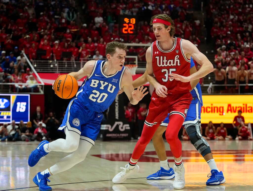 (Bethany Baker | The Salt Lake Tribune) Brigham Young Cougars guard Spencer Johnson (20) drives to the basket as he is defended by Utah Utes center Branden Carlson (35) at the Jon M. Huntsman Center in Salt Lake City on Saturday, Dec. 9, 2023.