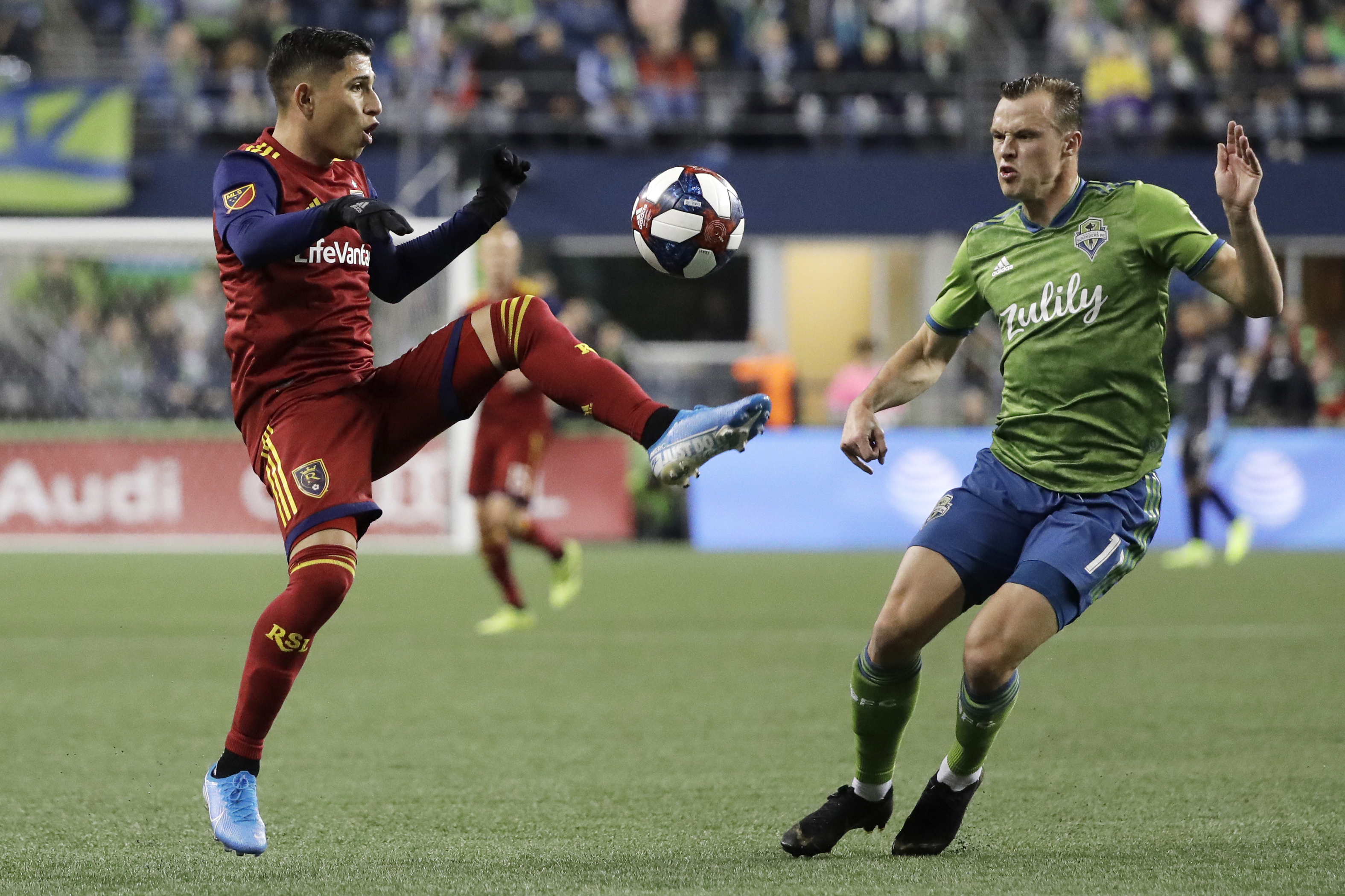 Real Salt Lake forward Jefferson Savarino, left, kicks the ball as Seattle Sounders defender Brad Smith, right, defends during the first half of an MLS Western Conference semifinal playoff soccer match Wednesday, Oct. 23, 2019, in Seattle. (AP Photo/Ted S. Warren)