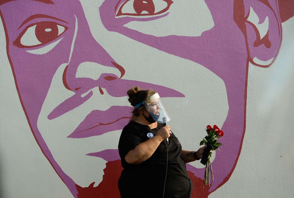 (Francisco Kjolseth | The Salt Lake Tribune) Gina Thayne, aunt of Dillon Taylor who raised him, speaks in front of his portrait as people gather for a vigil on the six-year anniversary of Taylor’s death by the murals of people killed by police near 800 South and 300 West in Salt Lake City on Tuesday, August 11, 2020.