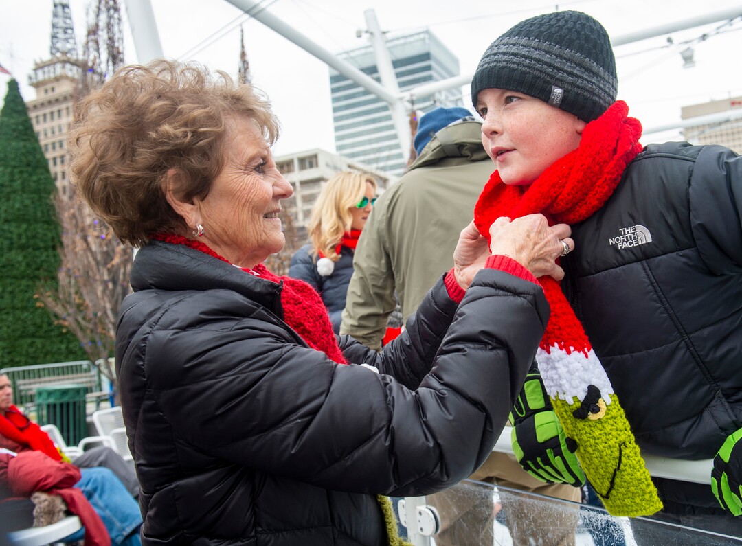 (Rick Egan  |  The Salt Lake Tribune)  Rosy Quinn fixes the scarf for Quinn Nikkel, 10, from San Diego, as they ice skate at the Gallivan Center ice rink, on Christmas Eve, Tuesday, Dec. 24, 2019. Quinn's family has been ice skating on Christmas Eve for the past 35 years. They are wearing Grinch scarves made by Diane Kortbawi so they can tell each other apart from the other skaters during their annual family ice skating outing.