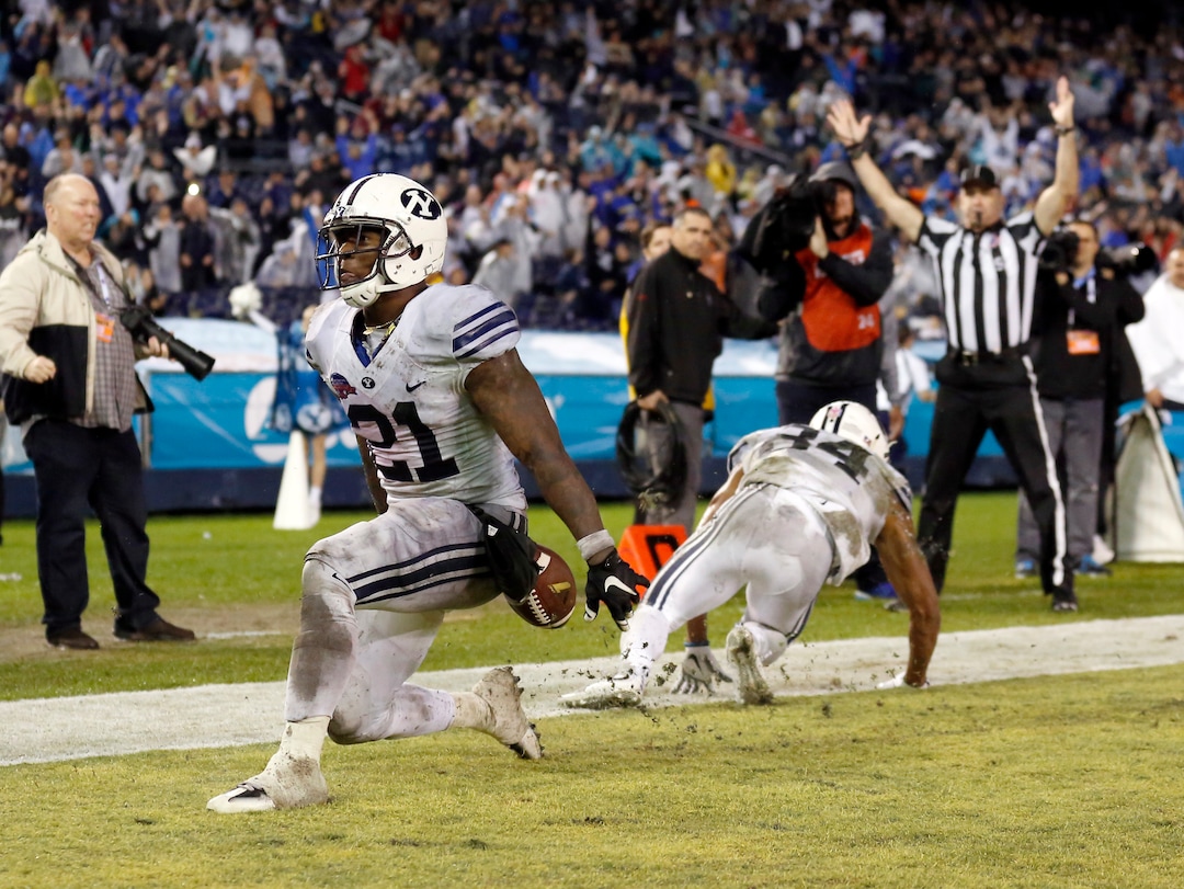 BYU running back Jamaal Williams, left, scores a touchdown against Wyoming during the first half of the Poinsettia Bowl NCAA college football game Wednesday, Dec. 21, 2016, in San Diego. (AP Photo/Ryan Kang)