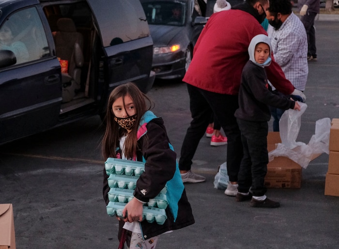 (Leah Hogsten | The Salt Lake Tribune) Volunteer Emileah LeBaron helps hand out food from the Utah Food Bank to needy families, Dec. 23, 2020.