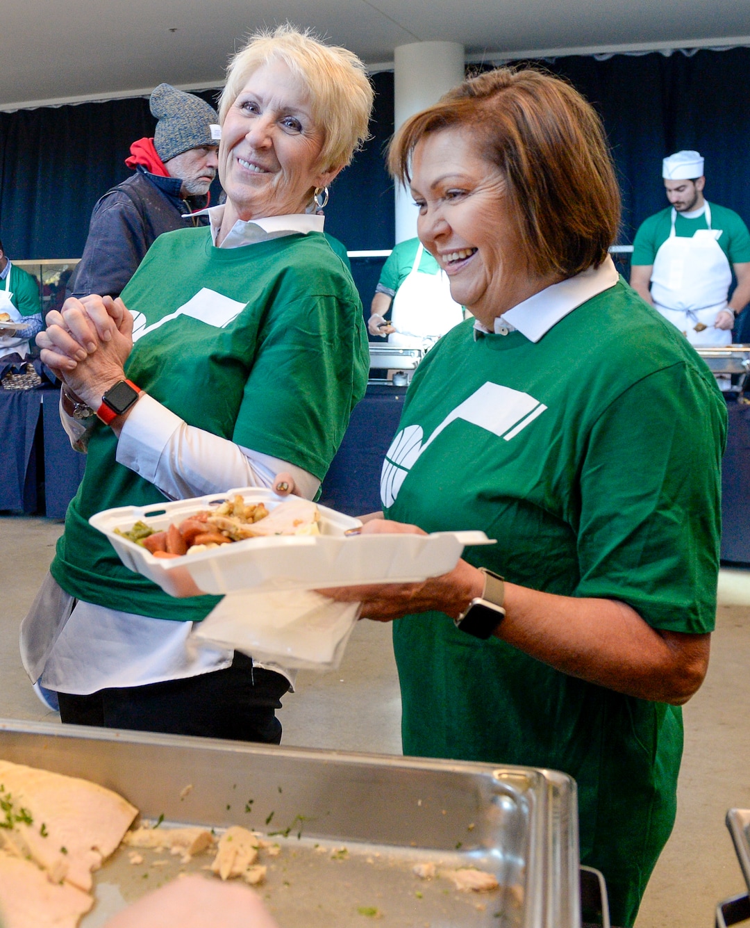 Leah Hogsten  |  The Salt Lake Tribune  l-r Kathy Farrow and Julene Jolley share a laugh with Jared Covington while filling a container with food for a woman who needed help at the  Utah Jazz and the Larry H. Miller Group sponsored annual “We Care – We Share” Thanksgiving Meal for local homeless and low-income families, Monday, Nov 19, 2018.