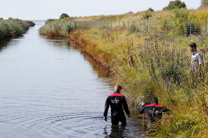 Police search a waterway for body remains related to the ongoing Kim Wall murder investigation at the west coast of Amager close to Copenhagen, Denmark, Wednesday, Aug. 23, 2017.  The investigation continues after the headless torso identified as that of missing Swedish journalist Kim Wall, was found on a beach off Copenhagen.(Jens Dresling / ritzau via AP)