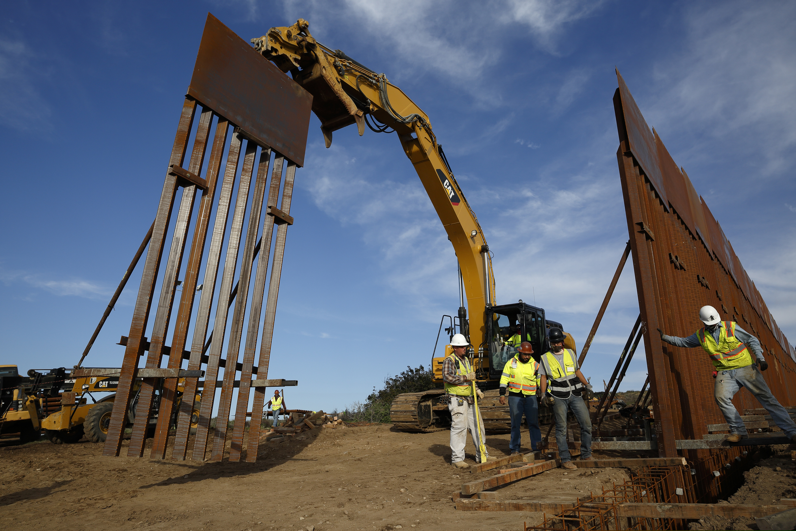(AP Photo/Gregory Bull, File) In this Jan. 9, 2019 file photo, construction crews install new border wall sections seen from Tijuana, Mexico. What started as an online fundraiser to provide President Donald Trump with donations for his southern border wall has morphed into a new foundation whose members vow to build a wall themselves. The "We The People Will Build the Wall" campaign has surpassed $20 million since it was created in December by Air Force veteran and triple amputee Brian Kolfage.