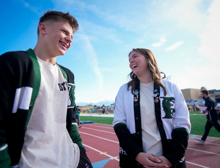 (Bethany Baker | The Salt Lake Tribune) Payson senior Ryland Baker, left, and Payson junior Sophie Savage laugh during an interview before a charity event to commemorate the 40th anniversary of the movie "Footloose" on the football field of Payson High School in Payson on Saturday, April 20, 2024.