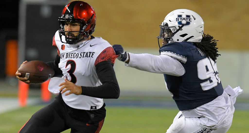 San Diego State quarterback Carson Baker (3) runs as Utah State defensive lineman Marcus Moore (95) chases him during the first half of an NCAA college football game Saturday, Oct. 31, 2020, in Logan, Utah. (Eli Lucero/The Herald Journal via AP, Pool)