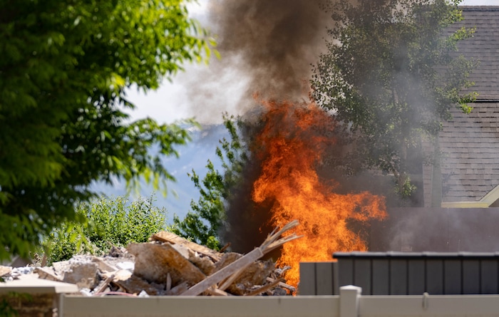 (Francisco Kjolseth | The Salt Lake Tribune) South Jordan tears down a house where an owner kept a stockpile of explosives, as fire agencies help burn off residual explosives that remained in the basement of the home and could not be safely removed on Tuesday, June 1, 2021.