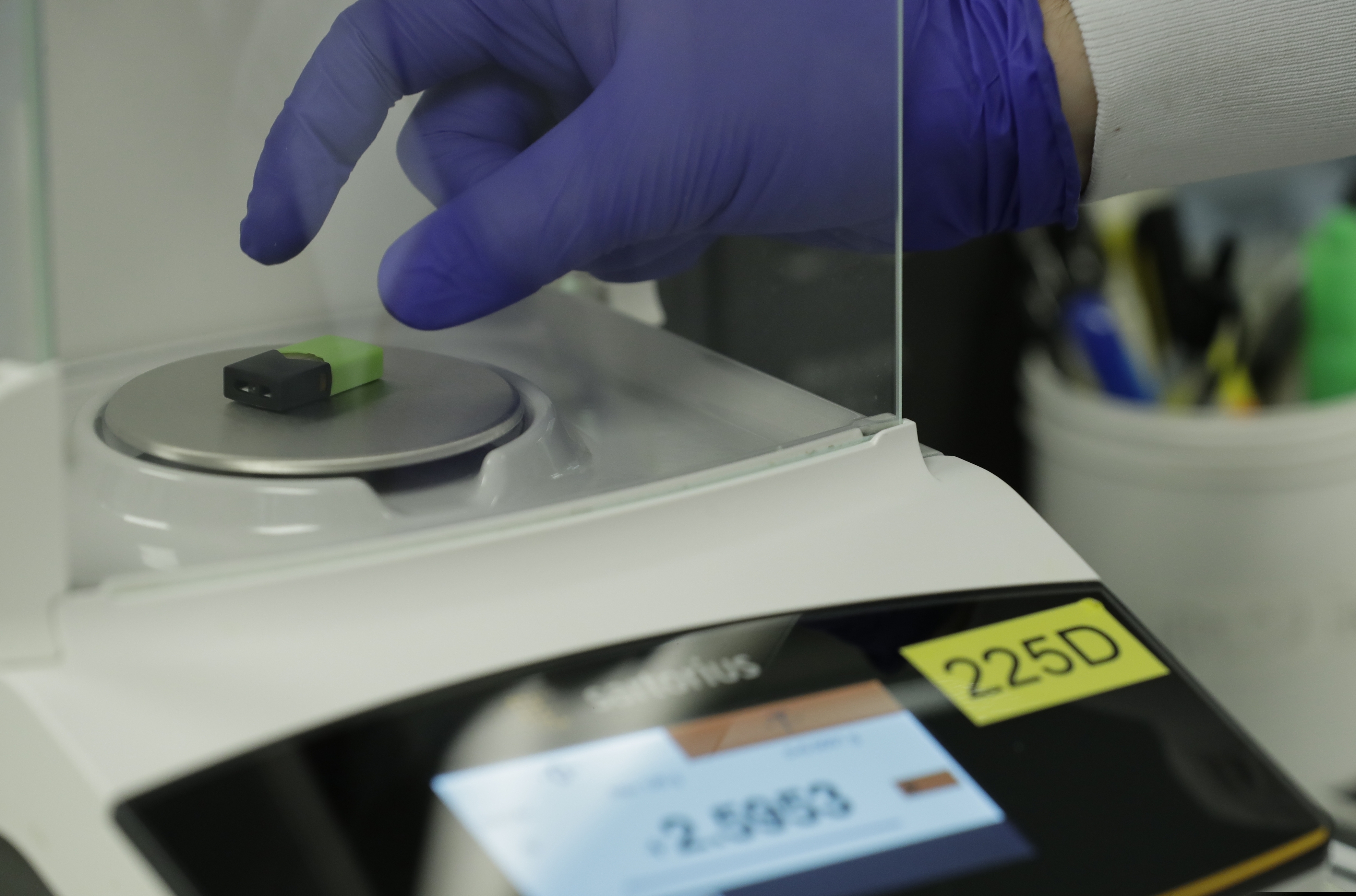 (Ted Warren | AP file photo) A Green Machine brand CBD vape pod is weighed during testing at Flora Research Laboratories in Grants Pass, Ore., on July 18, 2019. As part of an investigation into CBD vapes, The Associated Press commissioned the lab to test vape products purchased around the country, including seven Green Machine pods bought at stores in California, Florida and Maryland. Four of the Green Machine pods contained synthetic marijuana, a dangerous street drug commonly known as K2 or spice.