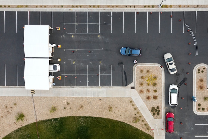 (Leah Hogsten  |  The Salt Lake Tribune) A line of cars bends around the University Of Utah Hospital's parking lot as people wait for COVID-19 testing in Farmington, Oct. 23, 2020.