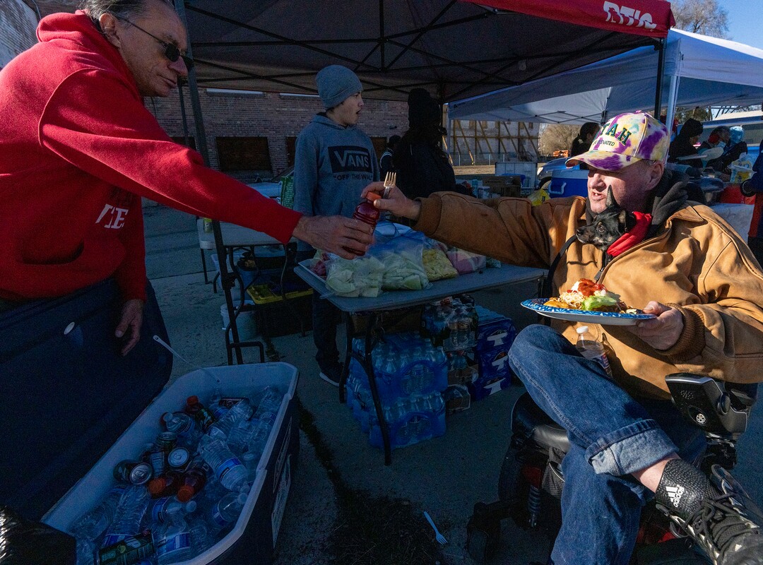 (Rick Egan | The Salt Lake Tribune) Keith Lail and his dog Sissy get a Navajo Taco, during a "Gratitude Dinner" served by volunteers from the group Black Lives for Humanity, on 500 West in Salt Lake City, on Thursday, Nov. 25, 2021. The group served   to more than 100 people from the unsheltered population, with donations from the community.