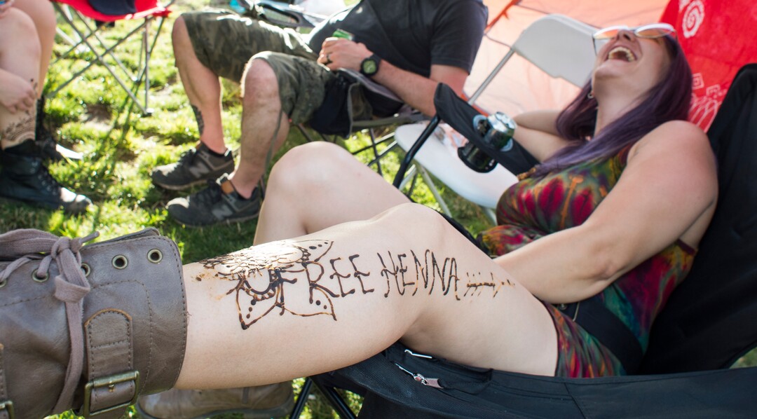 (Rick Egan  |  The Salt Lake Tribune)   Stephanie Burt, from South Jordan, advertise free henna tattoos, at the Reggae Rise Up Festival at the Rivers Edge in Heber City, Friday, Aug. 24, 2018.