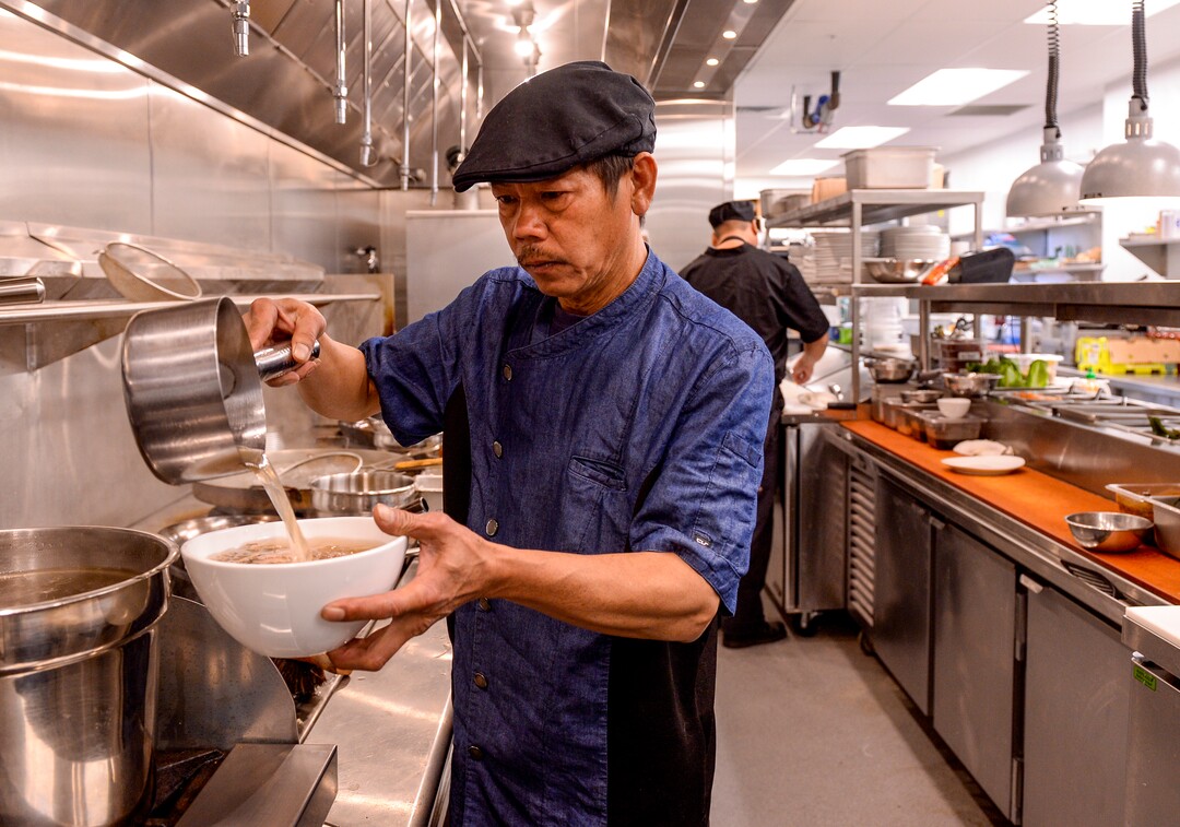 (Leah Hogsten  |  The Salt Lake Tribune)  Saola co-owner and chef Tuan Vu prepares a bowl of brisket pho, made with a clear aromatic broth poured over rice noodles, onion, cilantro and scallion, $15. Saola restaurant, located in Cottonwood Heights, serves Vietnamese food using locally sourced ingredients.