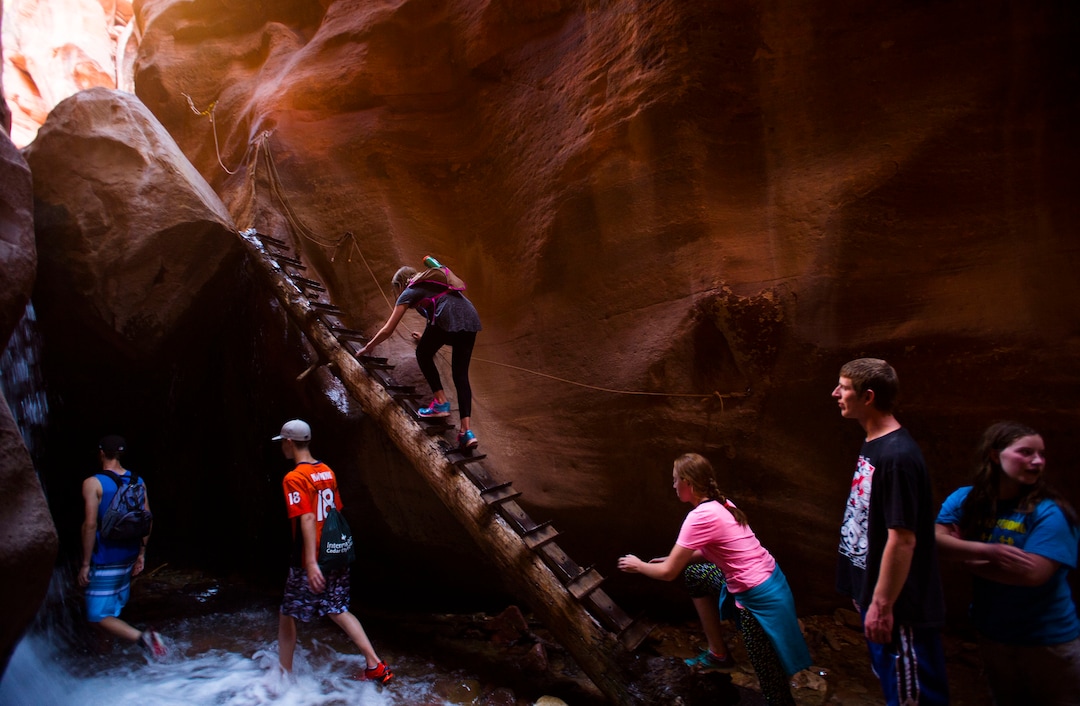 (Steve Griffin / The Salt Lake Tribune) Hikers climb a ladder made from a tree at the first falls of the Kanarraville Falls hike in Kanarraville  Wednesday July 6, 2016. 