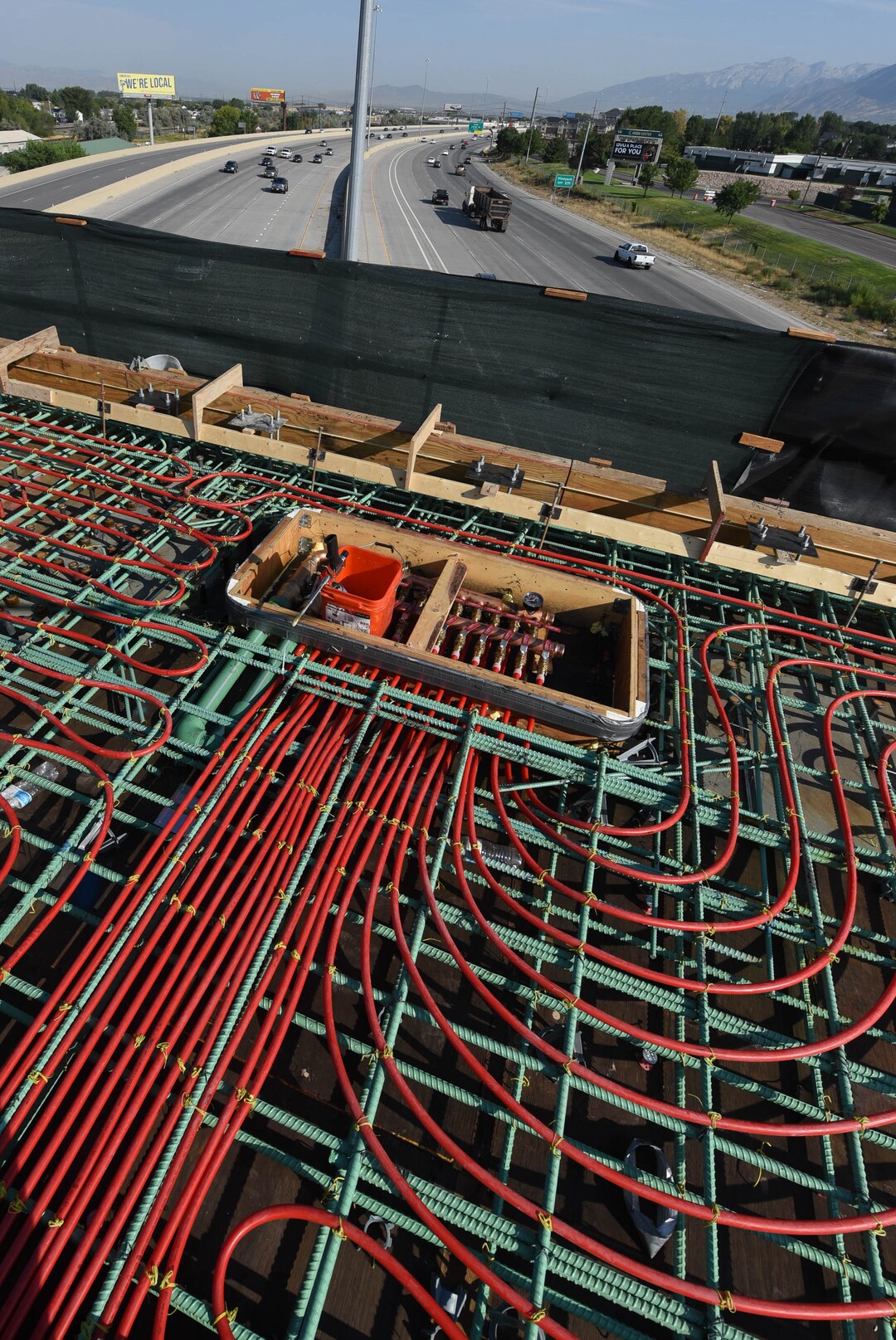 (Francisco Kjolseth  |  The Salt Lake Tribune) UDOT gives a tour of the state’s new longest pedestrian bridge on Thursday, August 20, 2020, connecting Utah Valley University in Orem to student housing and the community on the West side of I-15. Crews are finishing up an extensive hydronic heating system that will pump warm water to keep the bridge clear of snow in the winters, as it gets ready to pour concrete for the walking surface. UDOT will close I-15 in both directions this weekend for work on the nearly 1,000 foot bridge that is 15 feet wide to accommodate pedestrians, cyclists and scooters. Elevators and stairs with small ramps to push up bicycles will be on each side of the bridge.