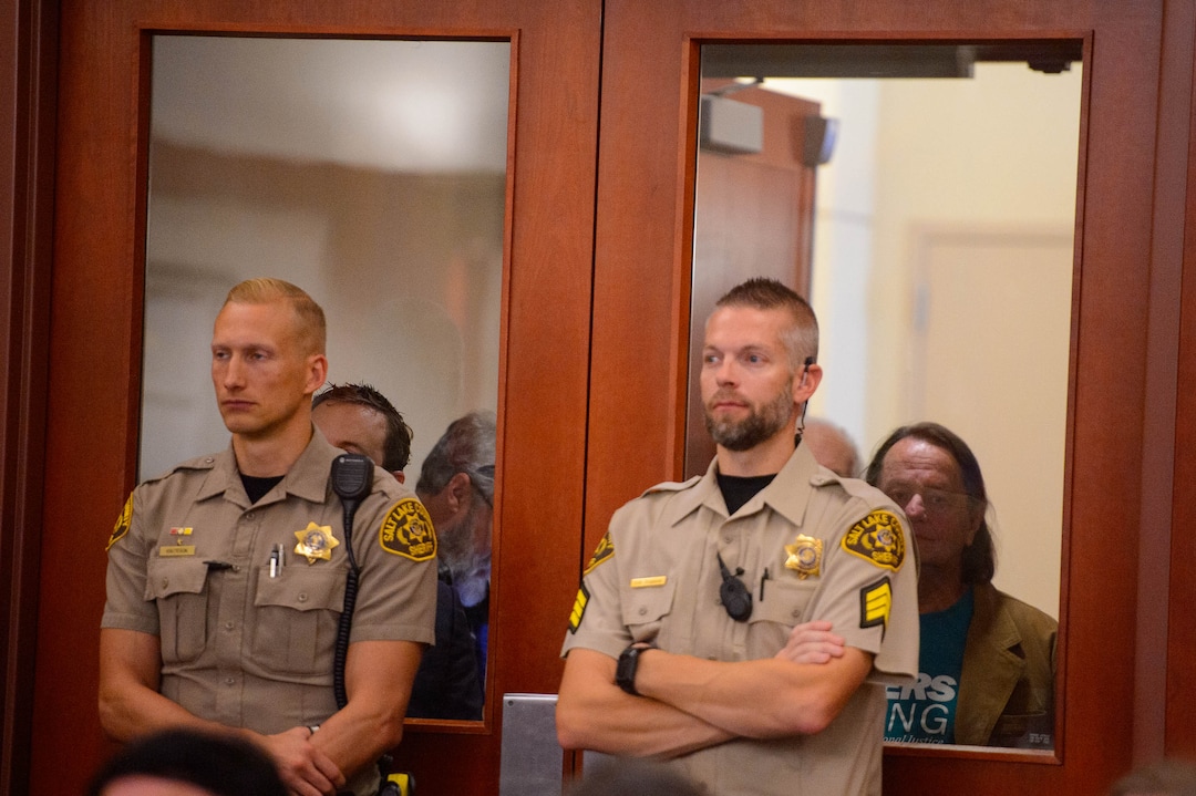 (Trent Nelson  |  The Salt Lake Tribune) Citizens look into the courtroom over the shoulders of bailiffs during a hearing on Salt Lake City’s case against the creation of the Utah Inland Port, a controversial international trading hub planned for a large swath of the municipality’s northwestern side, in Salt Lake City on Monday Nov. 18, 2019.