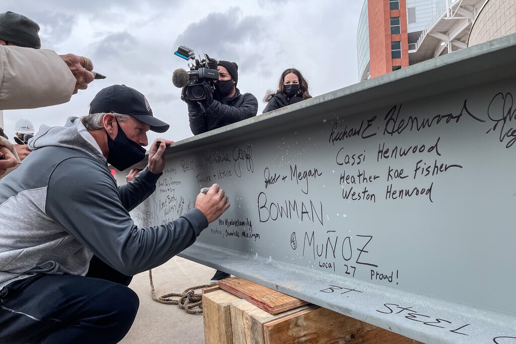 (Trent Nelson  |  The Salt Lake Tribune) University of Utah football coach Kyle Whittingham leans in to sign the final steel beam being raised into place at Rice-Eccles Stadium in Salt Lake City on Wednesday, Jan. 27, 2021.