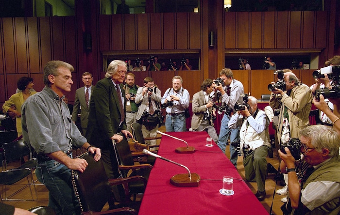 FILE - In this Sept. 6, 1995, file photo, photographers capture the arrival on Capitol Hill in Washington of Randy Weaver, left, and his attorney Gerry Spence for a hearing of a Senate Judiciary subcommittee. It's been a quarter century since a standoff in the remote mountains of northern Idaho left a 14-year-old boy, his mother and a federal agent dead and sparked the expansion of radical right-wing groups across the country that continues to this day. (AP Photo/Dennis Cook, File)