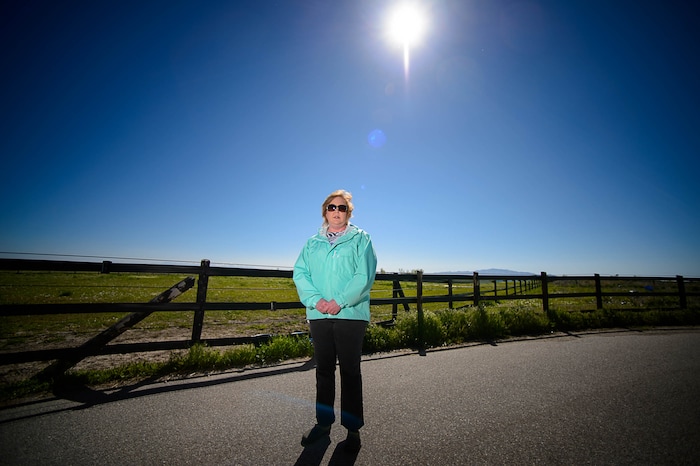 Trent Nelson | The Salt Lake Tribune
Christine Mikkelsen in the quiet open space behind her Farmington home that may soon be occupied by the West Davis Corridor highway, Thursday May 4, 2017. Mikkelsen and her husband moved into their home six years ago when they were told they would never lose their view thanks to the Buffalo Ranch that would prevent development from blocking the sweeping vista of the Great Salt Lake and Antelope Island. Later, when they learned about the West Davis Corridor, a roughly 20-mile stretch of new freeway planned in northern Utah, with a $600 million-plus price tag, Mikkelsen became heavily involved in the Save Farmington group that has opposed the project. “Most people who bought out here bought for the view, for the quiet and for the country feel,” Mikkelsen says. Now they will live with the noise and air pollution and a close up view of a freeway in their backyards and she says all state taxpayers will live with the bill of a very costly project.