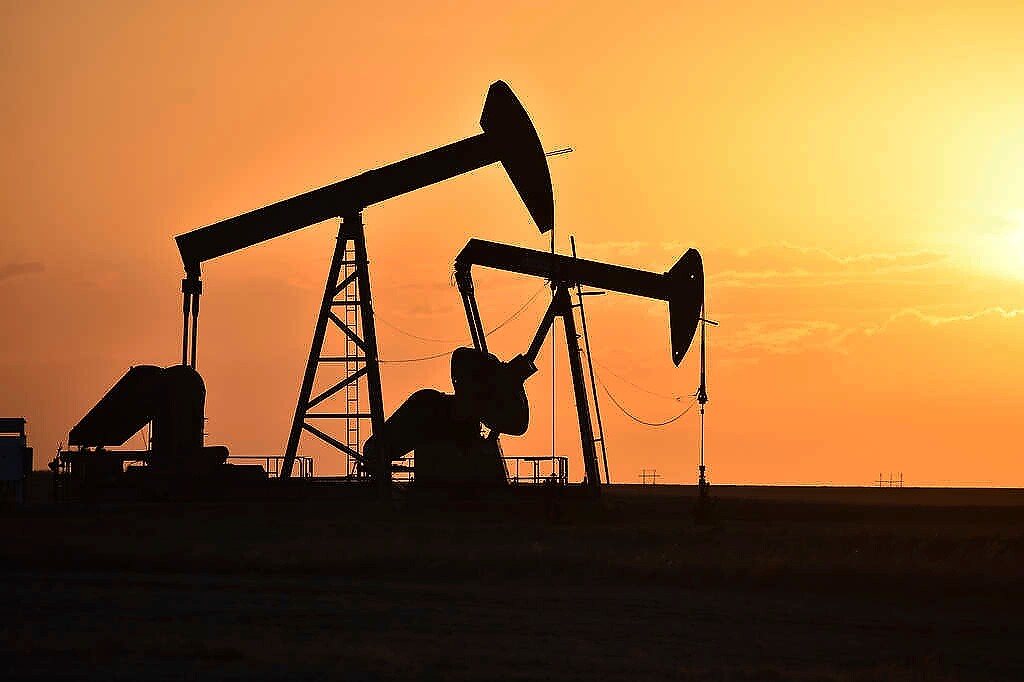 (Matthew Brown | AP) Pump jacks extract oil from beneath the ground on the Fort Berthold Indian Reservation east of New Town, N.D., May 19, 2021. On oil well pads carved from the wheat fields around Lake Sakakawea, hundreds of pump jacks slowly bob to extract 100 million barrels of crude annually from a reservation shared by three Native American tribes.