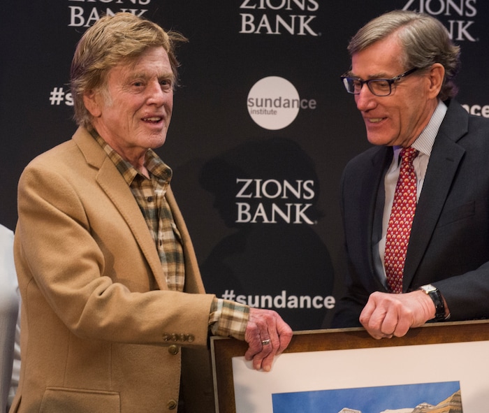 (Rick Egan  |  The Salt Lake Tribune)     Robert Redford receives an award from Scott Anderson, president and CEO of Zions Bank, at the 2018 Sundance Film Festival Utah Women’s Leadership Celebration in Park City on Thursday, Jan. 25, 2018.