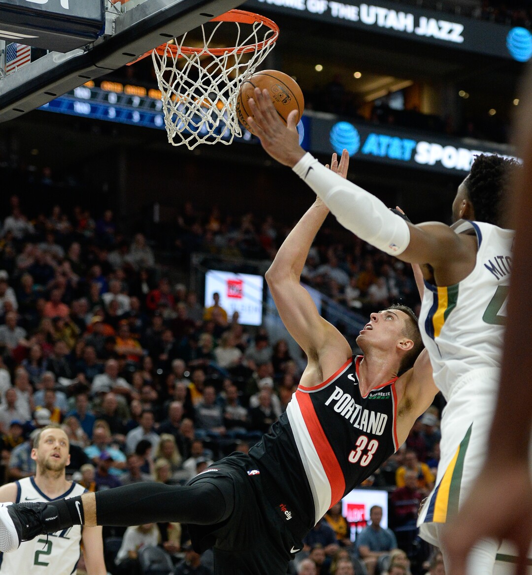 (Francisco Kjolseth  |  The Salt Lake Tribune)  Portland Trail Blazers forward Zach Collins (33) lays one up past Utah Jazz guard Donovan Mitchell (45) as the Utah Jazz host the Portland Trailblazers in their NBA basketball game at Vivint Smart Home Arena in Salt Lake City on Wed. Oct. 16, 2019.