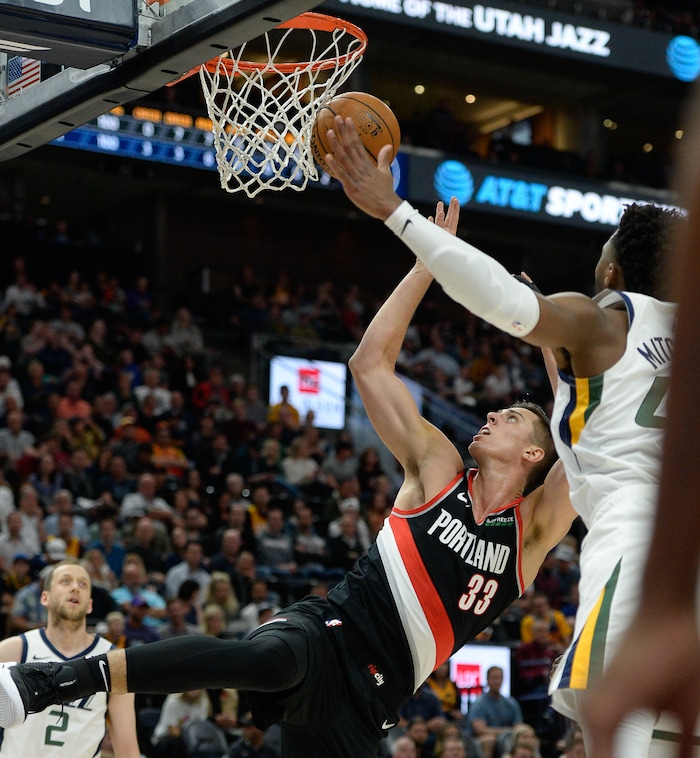 (Francisco Kjolseth  |  The Salt Lake Tribune)  Portland Trail Blazers forward Zach Collins (33) lays one up past Utah Jazz guard Donovan Mitchell (45) as the Utah Jazz host the Portland Trailblazers in their NBA basketball game at Vivint Smart Home Arena in Salt Lake City on Wed. Oct. 16, 2019.