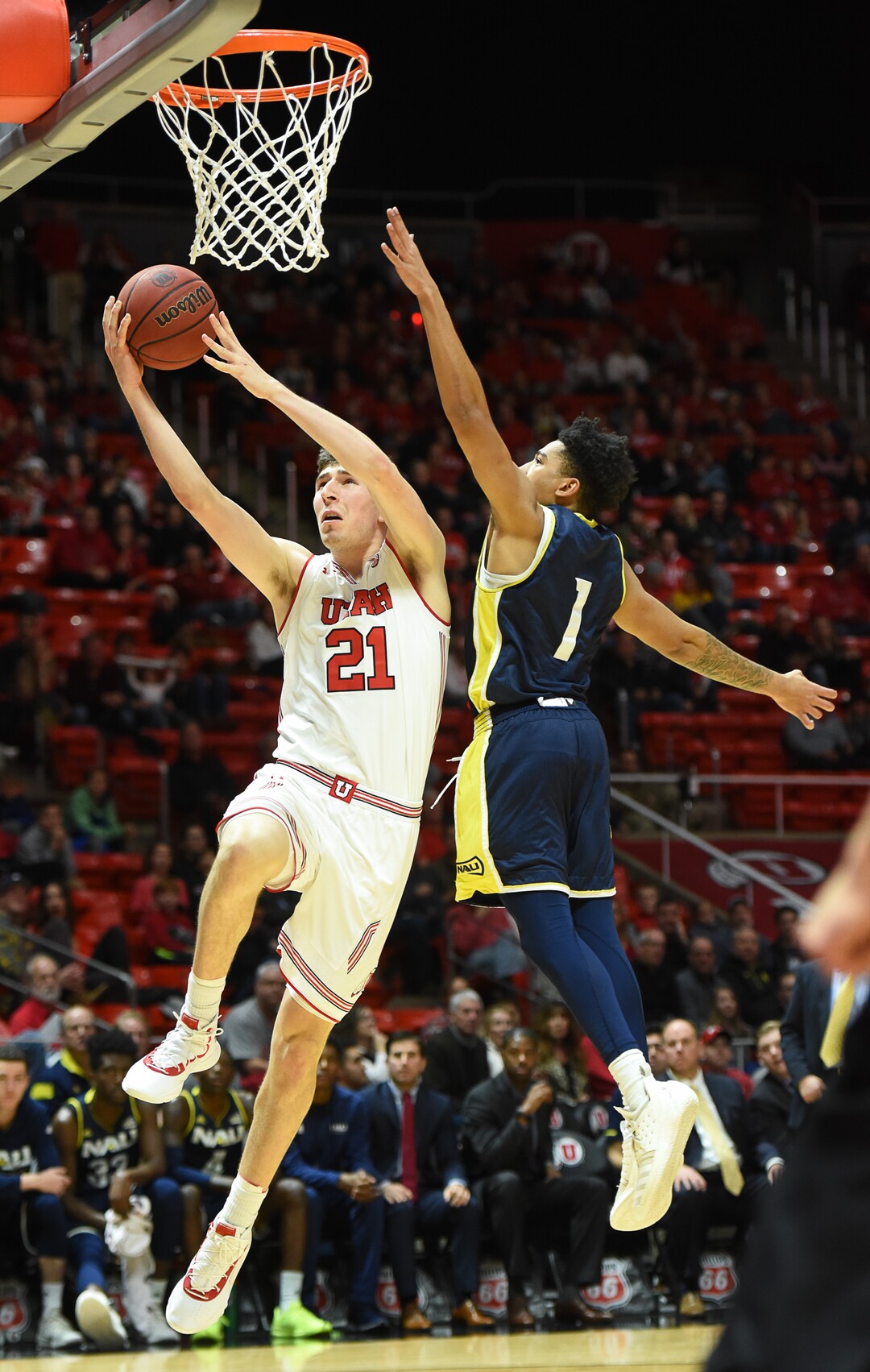 (Francisco Kjolseth  |  The Salt Lake Tribune)  Utah Utes forward Riley Battin (21) goes up for a shot past Northern Arizona Lumberjacks guard Davon Bolton (1) in Men's Basketball at the Jon M Huntsman Center in Salt Lake City, Utah, on Friday, Dec. 21, 2018.