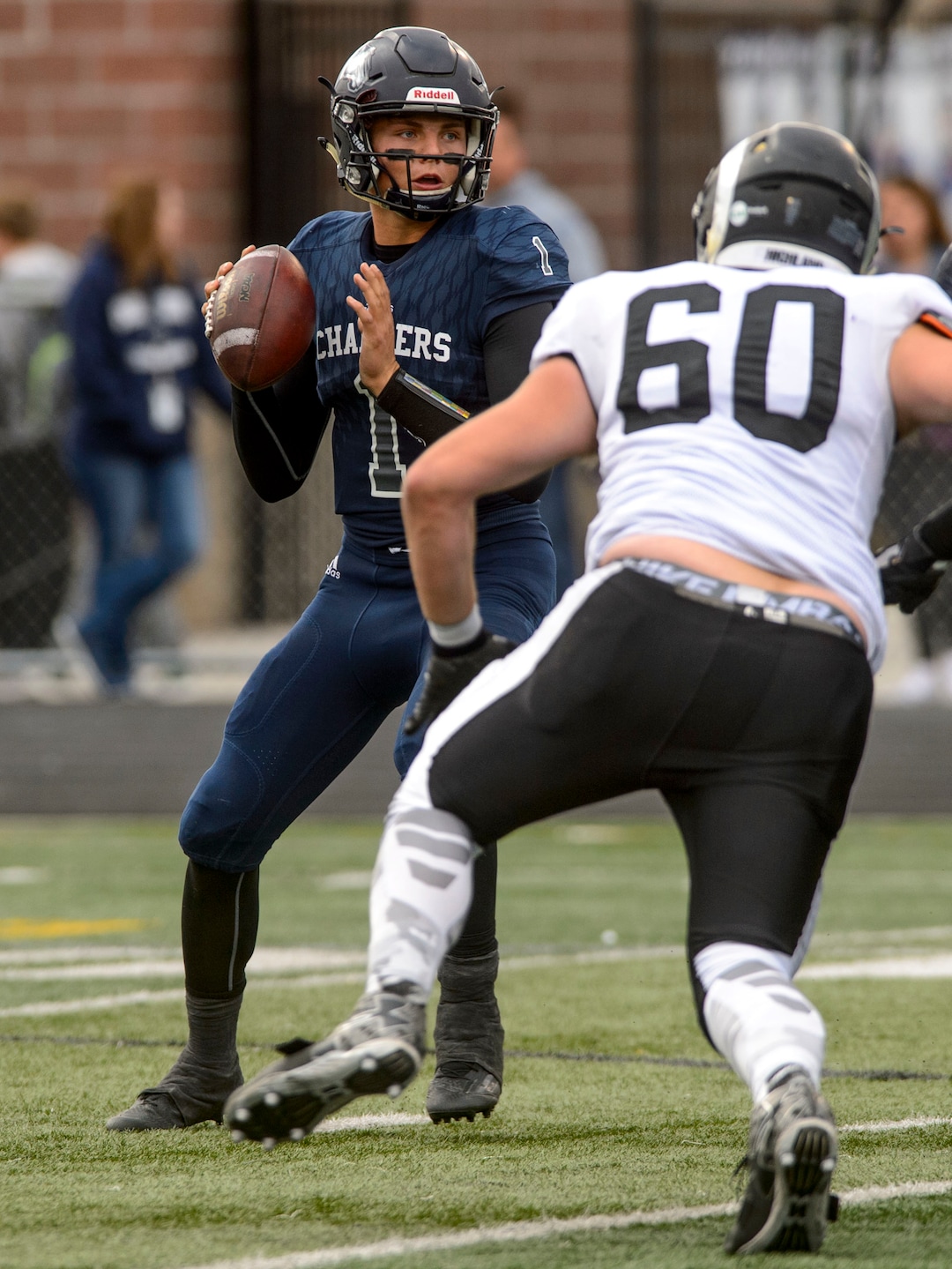 (Steve Griffin  |  The Salt Lake Tribune)  Corner Canyon quarterback Zach Wilson looks downfield as Highland  lineman Caden Hilborn closes in on him during the Class 5A state quarterfinal football game at Corner Canyon in Draper Friday November 3, 2017.